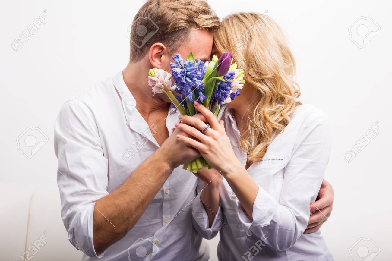 カップルがキスをし 非表示にする花を持って の写真素材 画像素材 Image