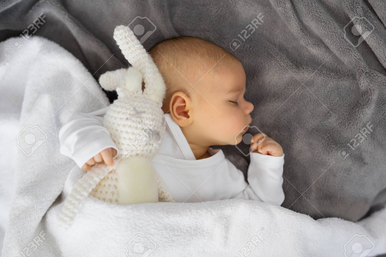 baby sleeping with stuffed animal