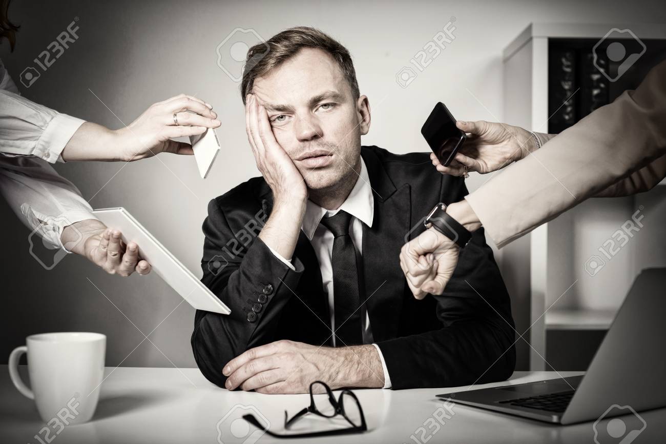 Man overwhelmed with tasks and responsibilities at work - 108462596 Man overwhelmed with tasks and responsibilities at work - 108462596