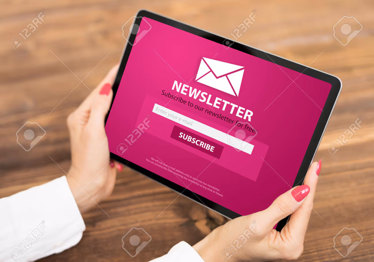 Woman holding tablet with newsletter signup page on screen - 165194440 Woman holding tablet with newsletter signup page on screen - 165194440