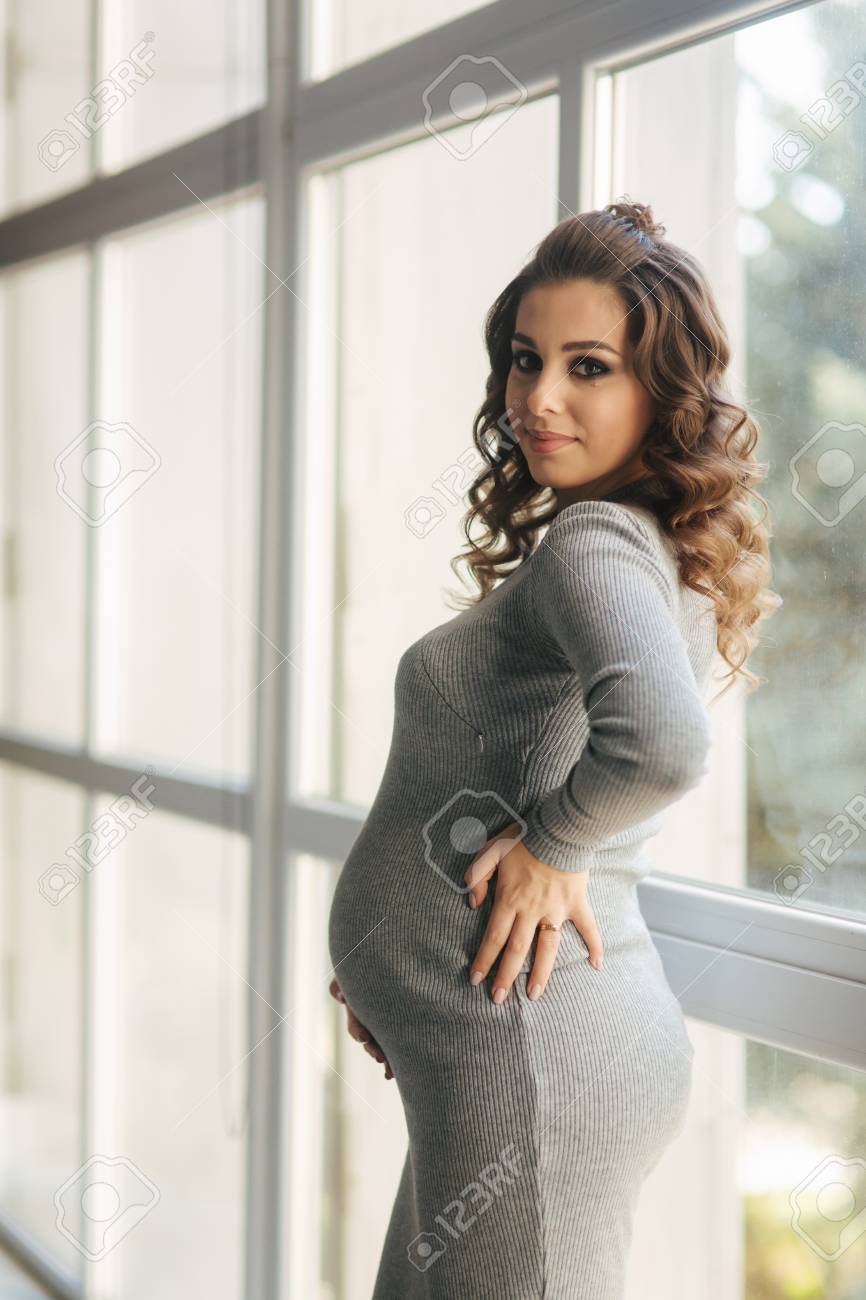 Beautiful Pregnant Woman Walks In The House Near A Large Window