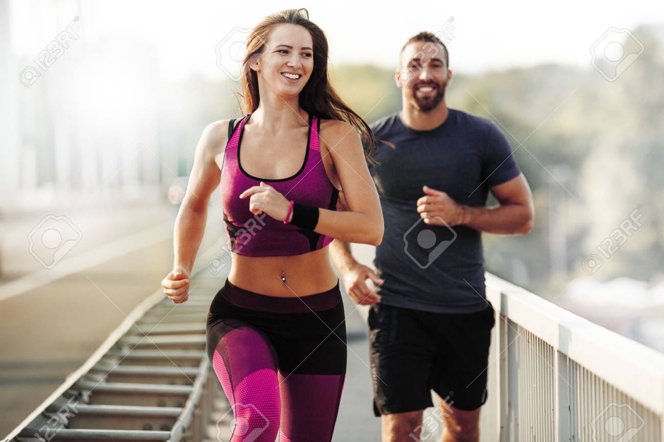 Happy couple running outdoors. People jogging together, living healthy lifestyle. - 62396849 Happy couple running outdoors. People jogging together, living healthy lifestyle. - 62396849