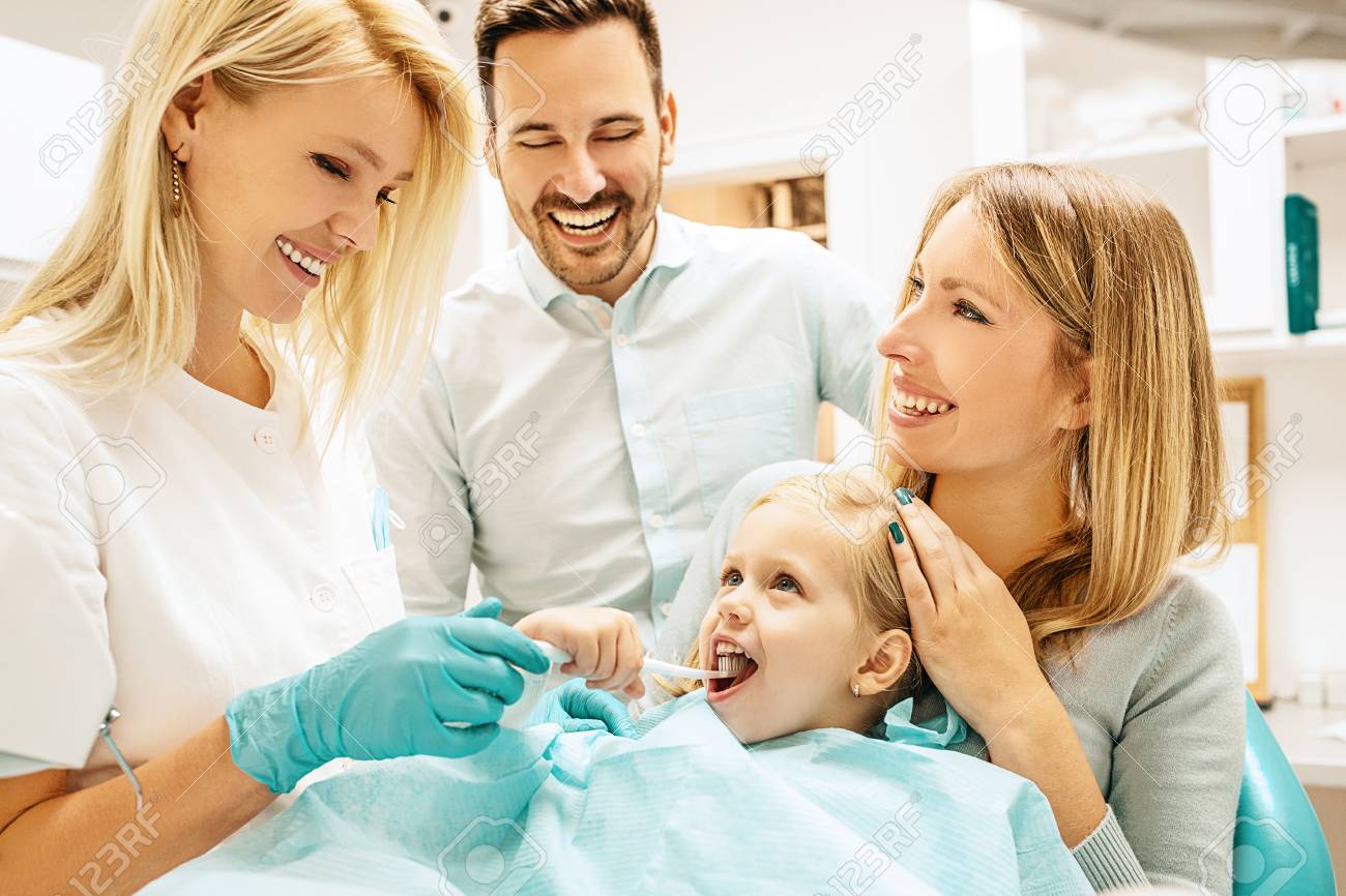 Dentist treating cute blonde child in his surgery. - 88404548 Dentist treating cute blonde child in his surgery. - 88404548