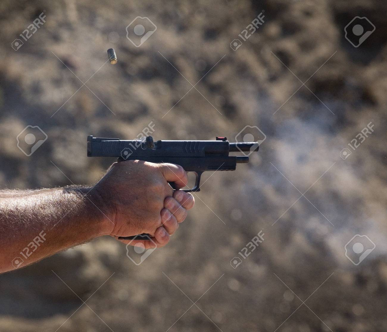 ポリマー拳銃から飛んでいる空の薬莢 の写真素材 画像素材 Image