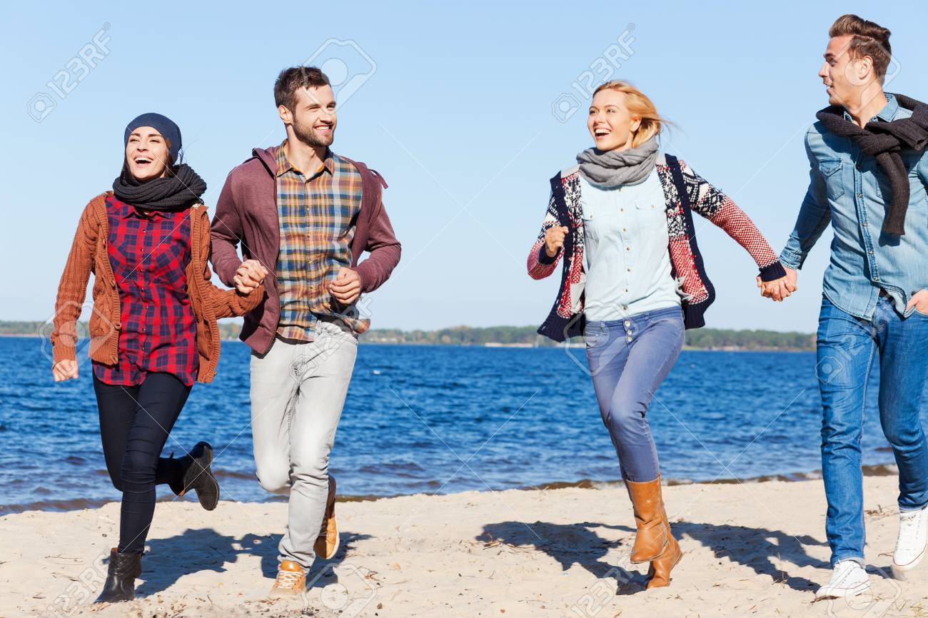 Fur Immer Jung Und Frei Zwei Gluckliche Junge Paare Laufen Am Strand Zusammen Und Lacheln Fur Immer Jung Und Frei Zwei Gluckliche Junge Paare Laufen Am Strand Zusammen Und Lacheln