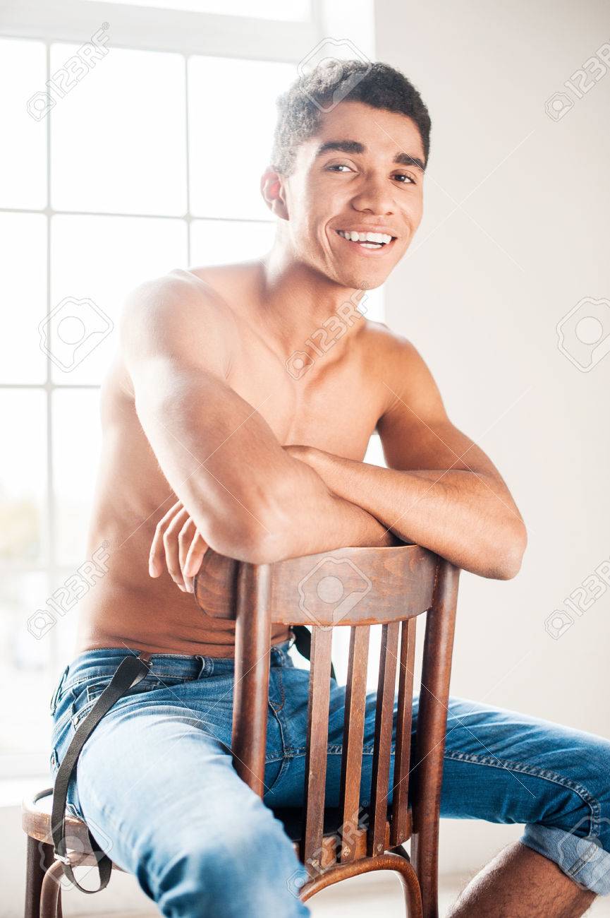 彫りの深い 魅力的です ハンサムな若いアフリカ系アメリカ人男椅子に座って カメラ目線 の写真素材 画像素材 Image