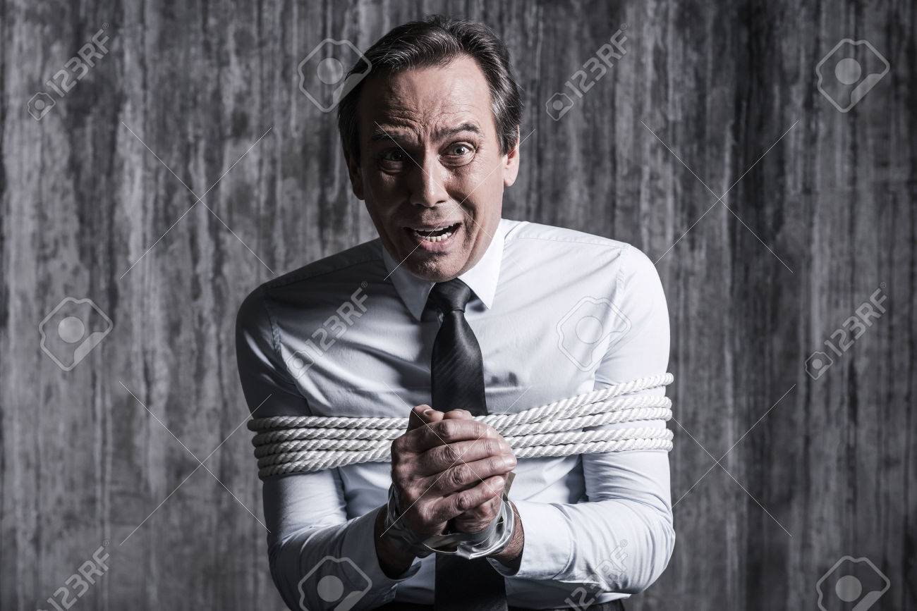 恐怖と絶望 バック グラウンドで壁の汚れで椅子に座っている間ショックを縛りビジネスマン確認ヘルプ の写真素材 画像素材 Image