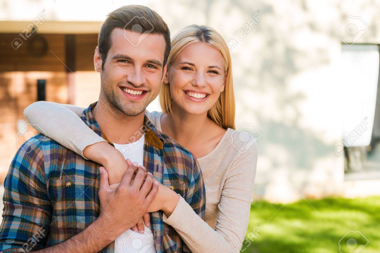 Jeune Et Amoureux Beau Jeune Couple Se Liant Les Uns Aux Autres Et Souriant Face A Leur Nouvelle Maison Banque D Images Et Photos Libres De Droits Image 41495949