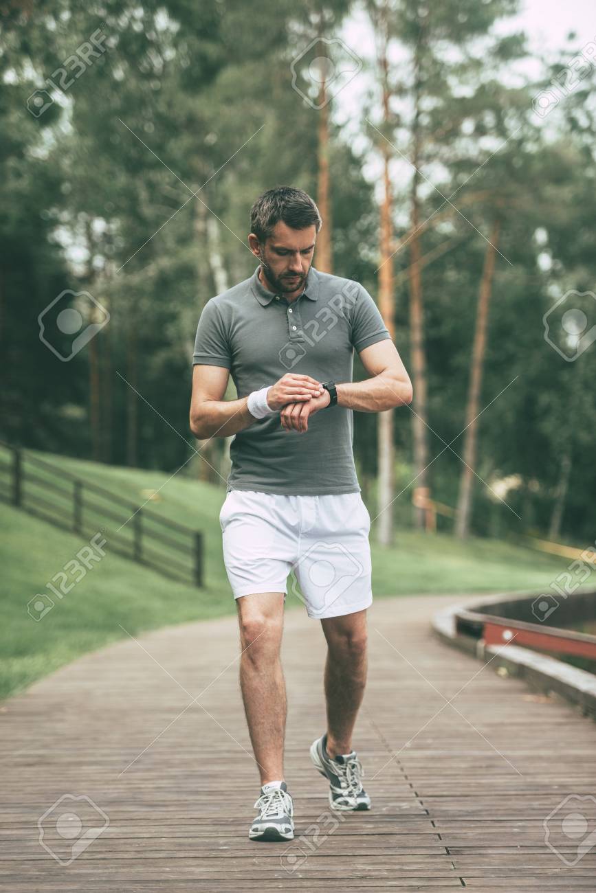 Marchant L'homme Dans Le La Confiant Les RésultatToute Bon Vêtements En De Nouveau Sport Longueur Tout Montre Regardant Sa Bracelet 5LR4Aj