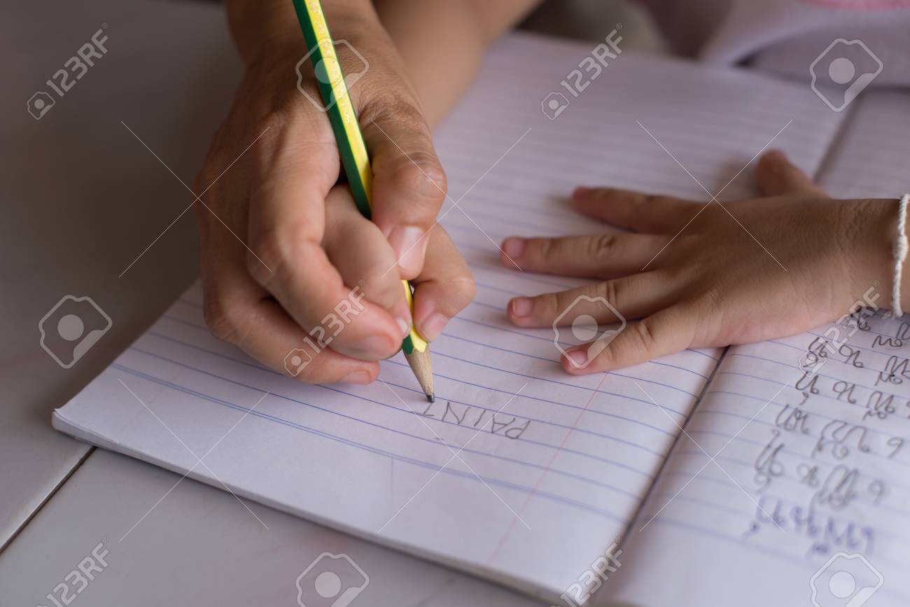 mother helping daughter do homework in workbook stock photo picture workbook stock