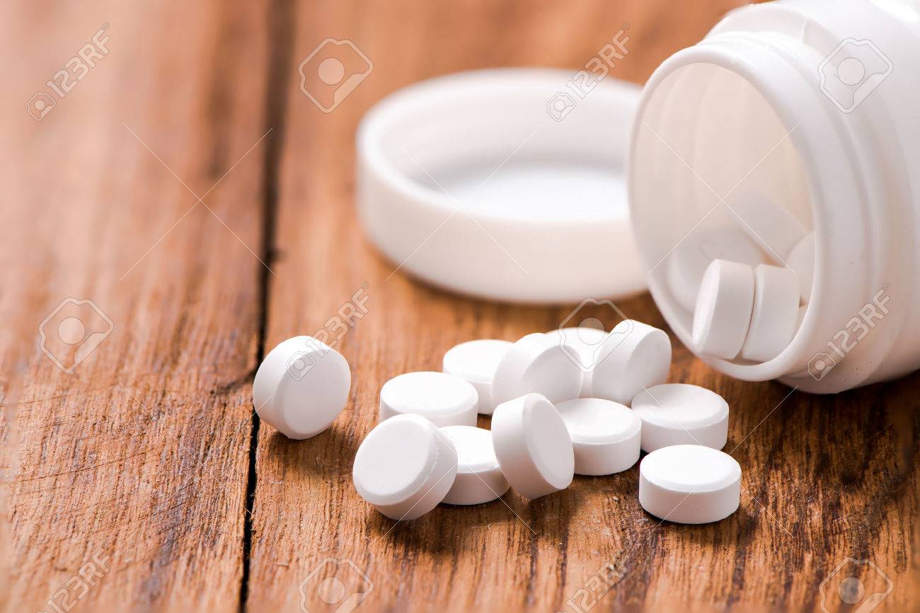 round pills on wood table,medicine - 51055251 round pills on wood table,medicine - 51055251