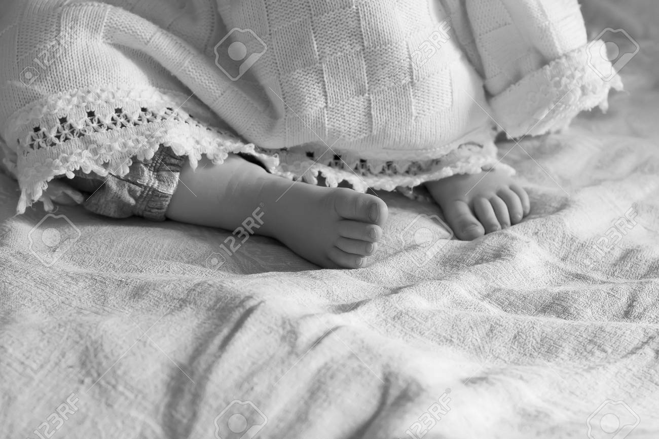ヒールの黒と白 選択的なフォーカスで毛布の下から突き出ている睡眠の赤ちゃん女の子 の写真素材 画像素材 Image