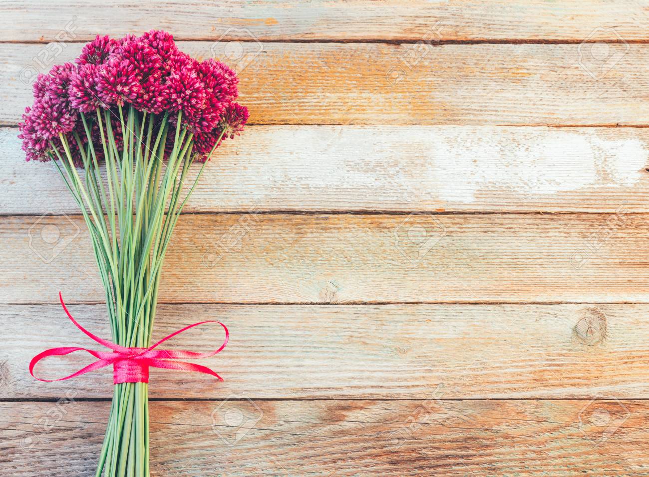 美しい紫のネギの花の花束は テキスト用のスペースを木製のレトロな背景に紫のリボンと結ばれます 平ら トップ ビュー の写真素材 画像素材 Image