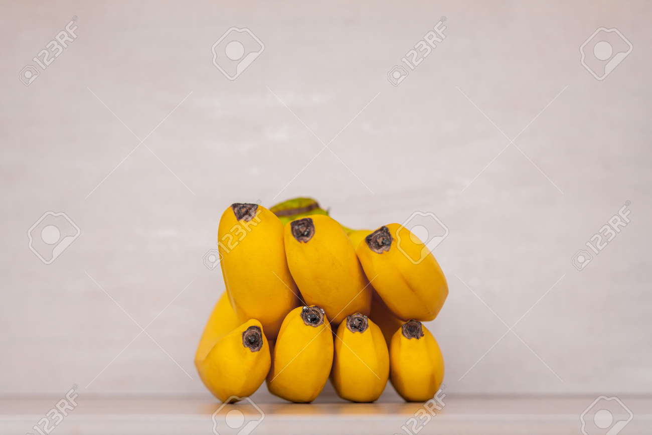 a bunch of yellow ripe bananas on a gray background close-up - 165439636 a bunch of yellow ripe bananas on a gray background close-up - 165439636
