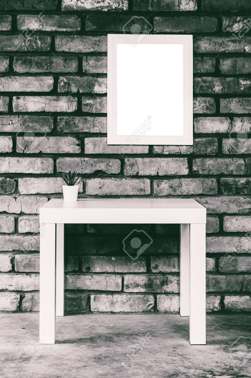 minimalistic loft-style interior with a white table, mock up white picture frame or photo frame on a brick wall, black and white photo - 171894971 minimalistic loft-style interior with a white table, mock up white picture frame or photo frame on a brick wall, black and white photo - 171894971