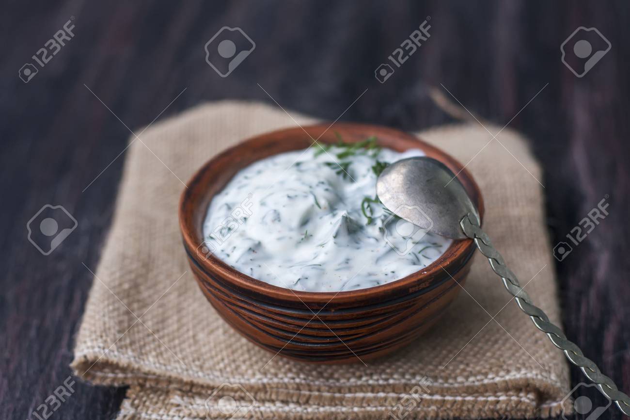 Bowl of fresh yogurt dip with dill and garlic on wooden background. selective Focus - 44913174 Bowl of fresh yogurt dip with dill and garlic on wooden background. selective Focus - 44913174