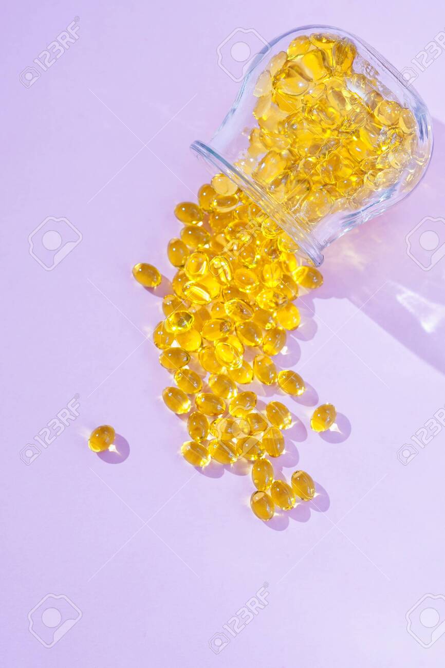 Capsules Vitamin D and Omega-3 tablets for a healthy diet on a pink background. Fish oil based supplement capsules. Healthy eating concept. Selective focus, opy space - 134385043 Capsules Vitamin D and Omega-3 tablets for a healthy diet on a pink background. Fish oil based supplement capsules. Healthy eating concept. Selective focus, opy space - 134385043