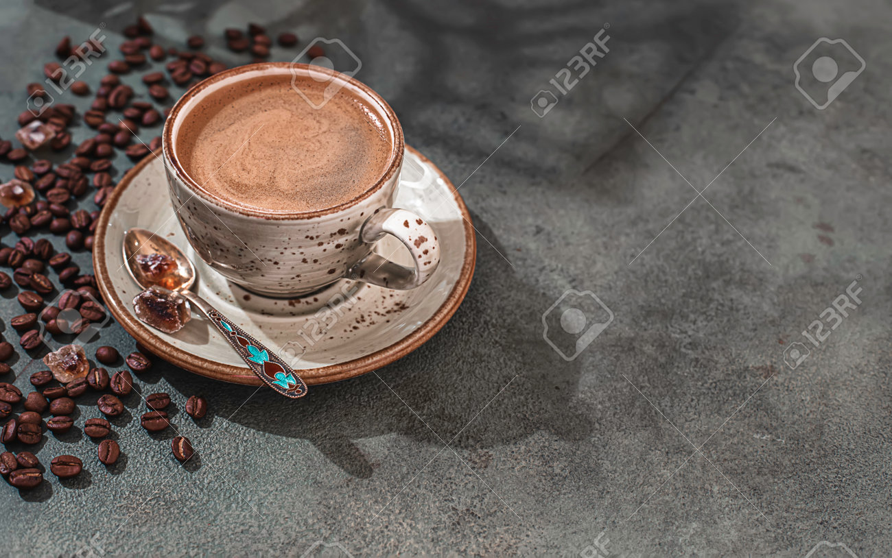 Fragrant strong coffee and coffee beans on a dark green concrete background. The concept of hot drinks. - 171765672 Fragrant strong coffee and coffee beans on a dark green concrete background. The concept of hot drinks. - 171765672
