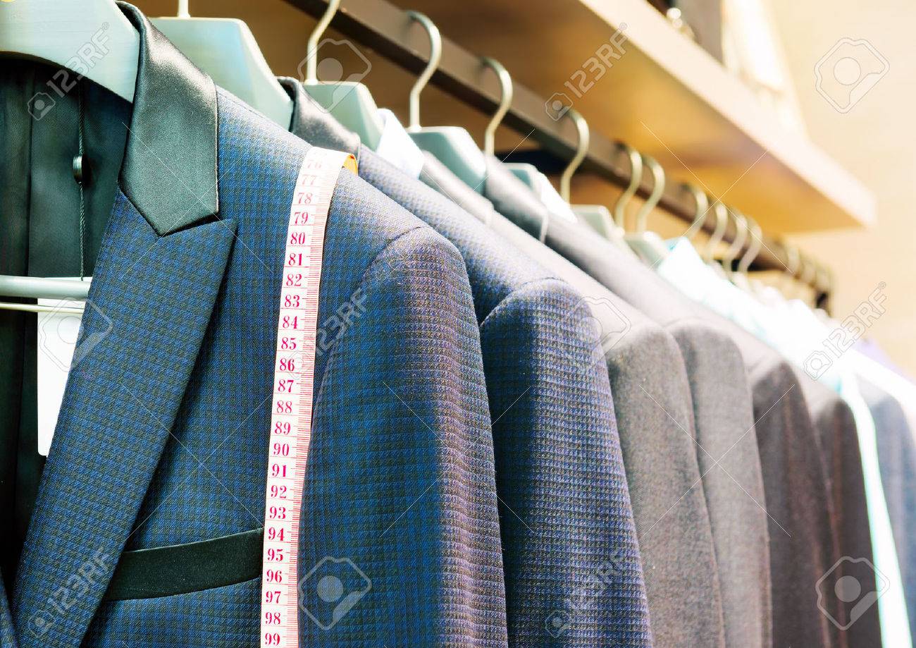 Row of men's suits hanging in closet. - 38293838 Row of men's suits hanging in closet. - 38293838