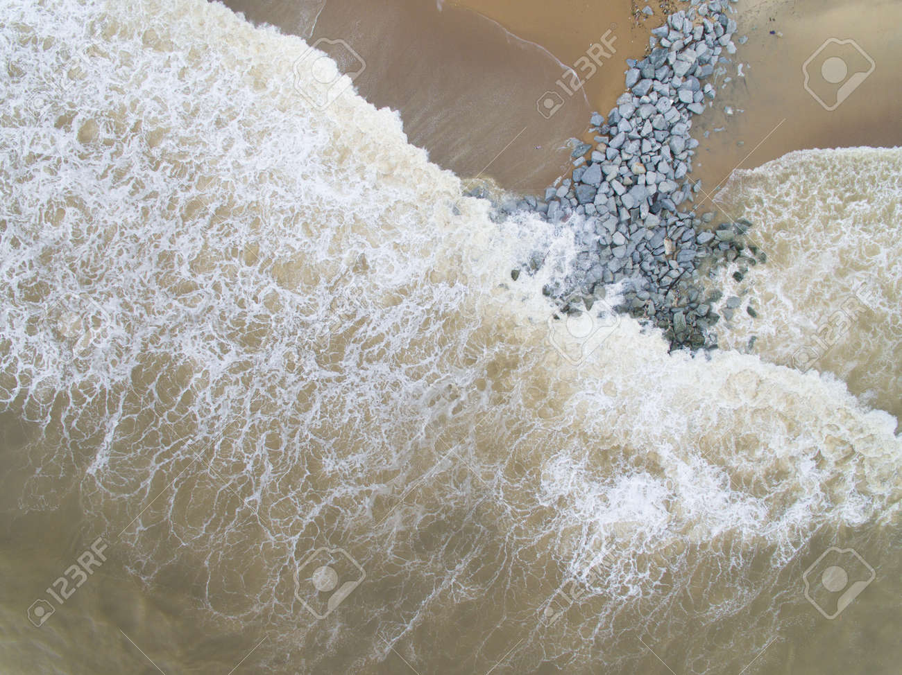 Aerial Top View Of Sea Waves Hitting Rocks On The Beach In Pantai