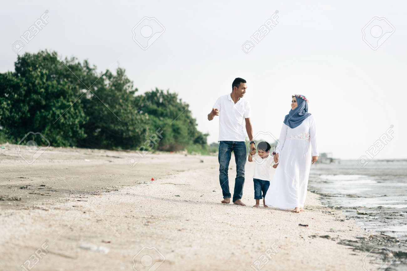 Happy Family Having Fun Time Walking Together At The Beach Located