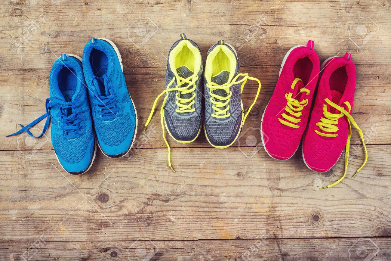 Various pairs of colorful sneakers laid on the wooden floor background - 36096506 Various pairs of colorful sneakers laid on the wooden floor background - 36096506
