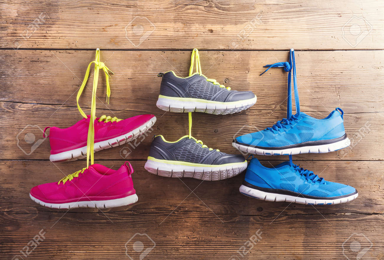 木製のフェンスの背景に爪にハングアップするスニーカーの 3 つのペア の写真素材 画像素材 Image