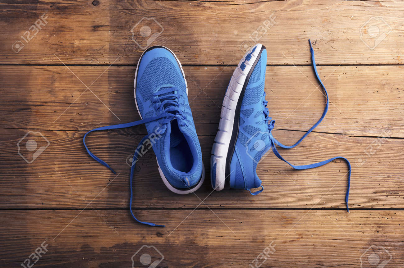 Pair of blue running shoes laid on a wooden floor background - 38905988 Pair of blue running shoes laid on a wooden floor background - 38905988