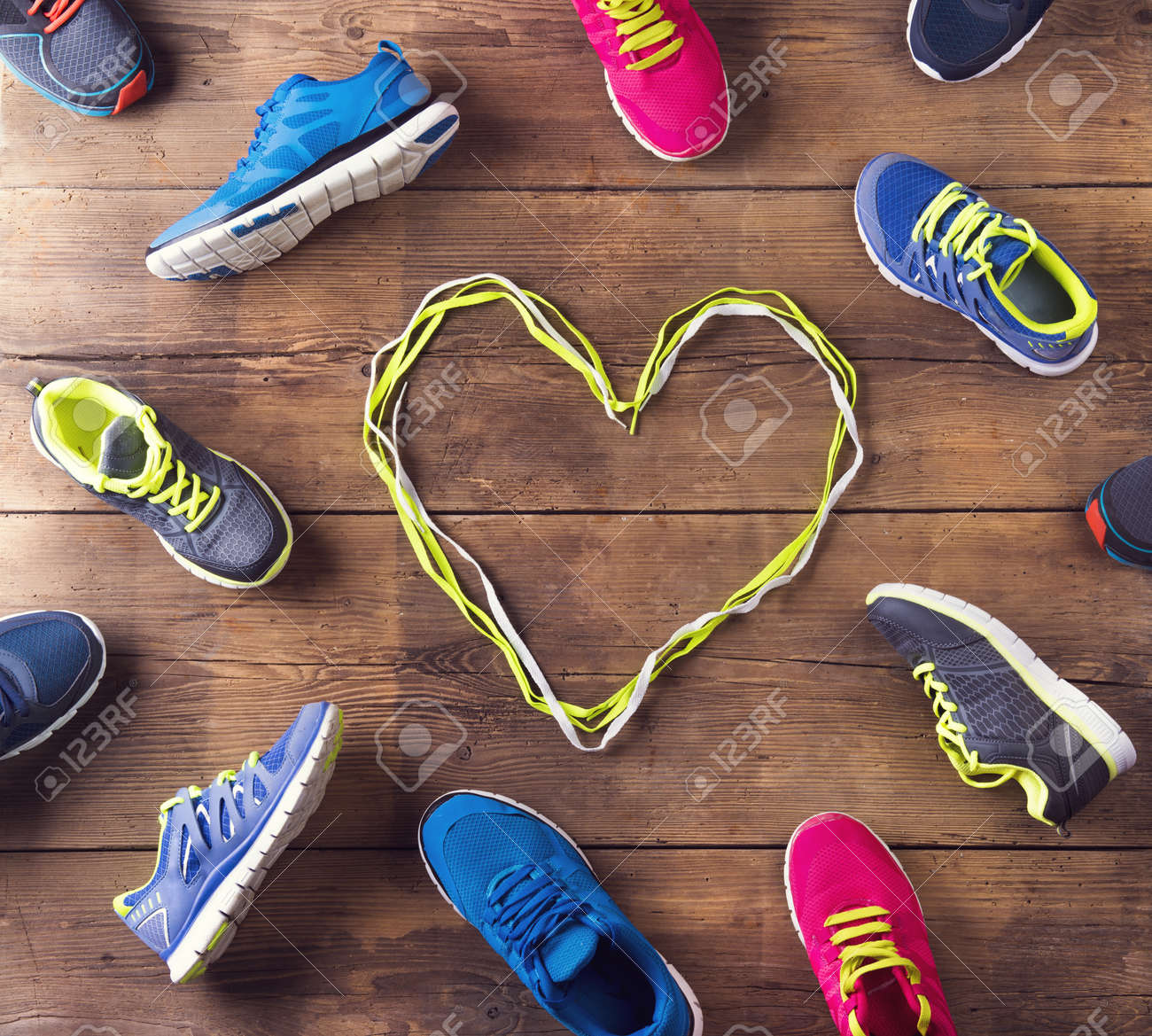 Various Running Shoes Laid On A Wooden Floor Background Stock