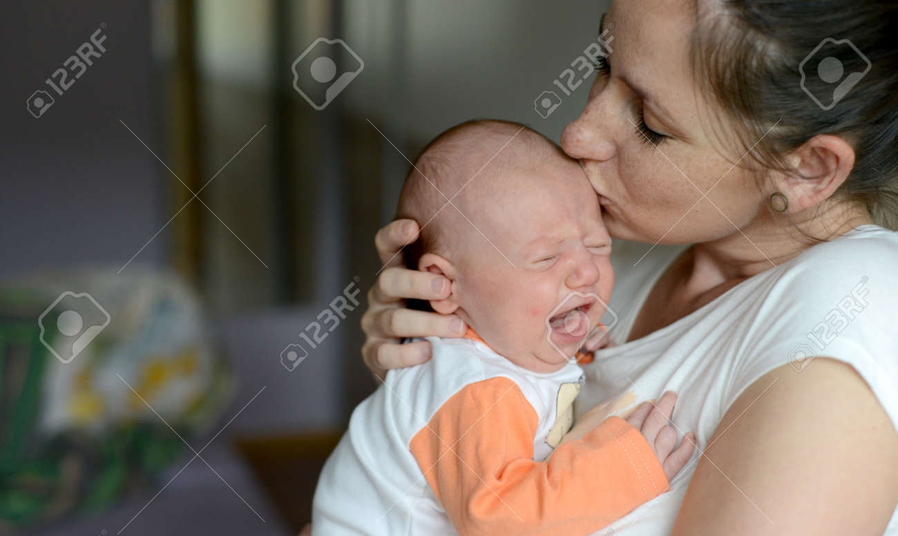 Close Up Of Young Mother Holding Her Cute Baby Daughter Kissing