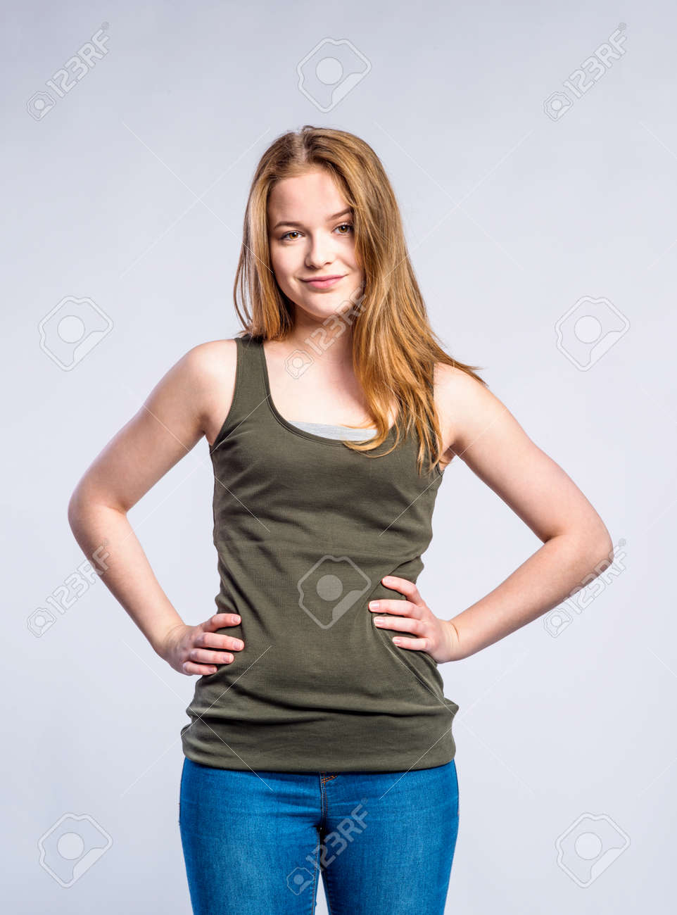 Teenage Girl In Jeans And Khaki Tank Top, Young Woman, Studio Shot On Gray  Background Stock Photo, Picture and Royalty Free Image. Image 58520429.