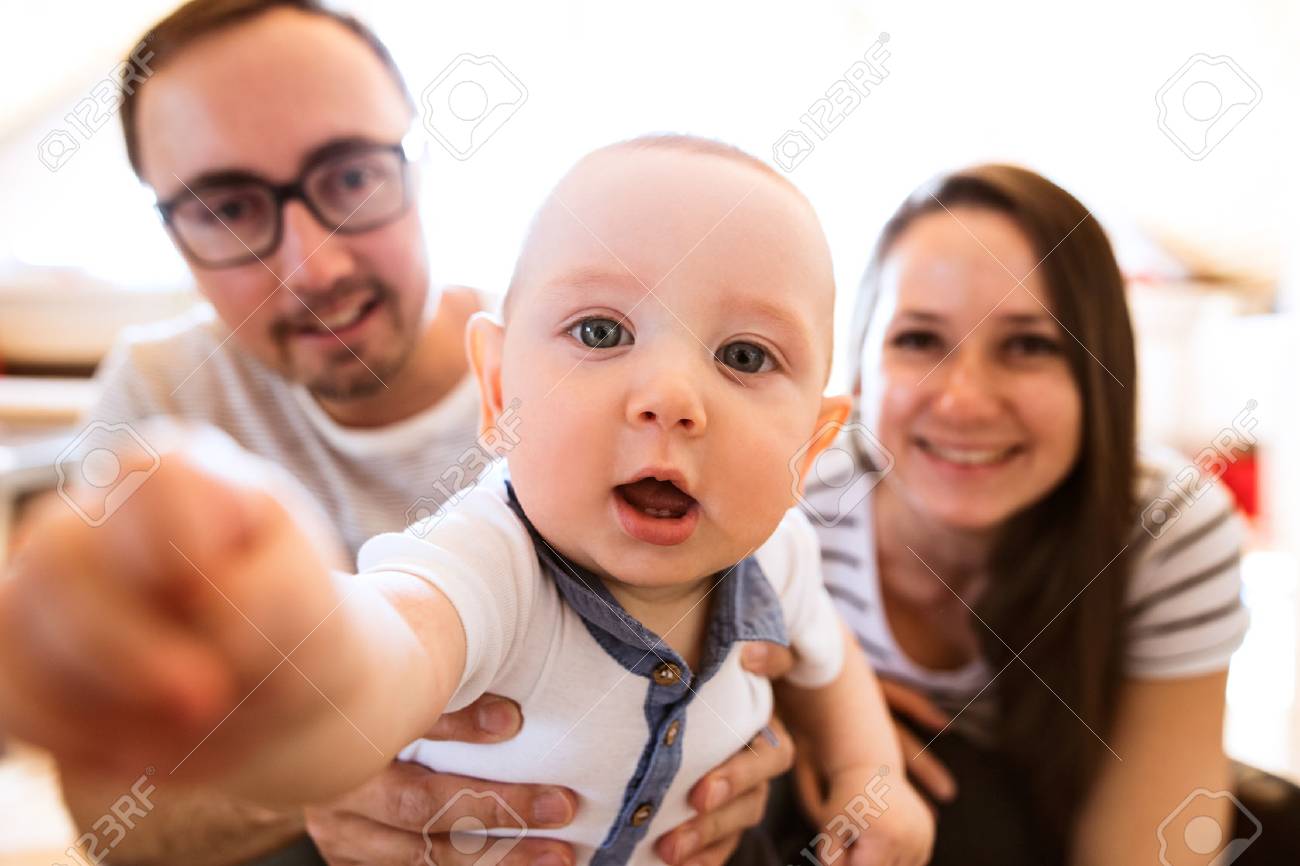 彼らのかわいい赤ちゃんの息子を保持している美しい若い親 の写真素材 画像素材 Image