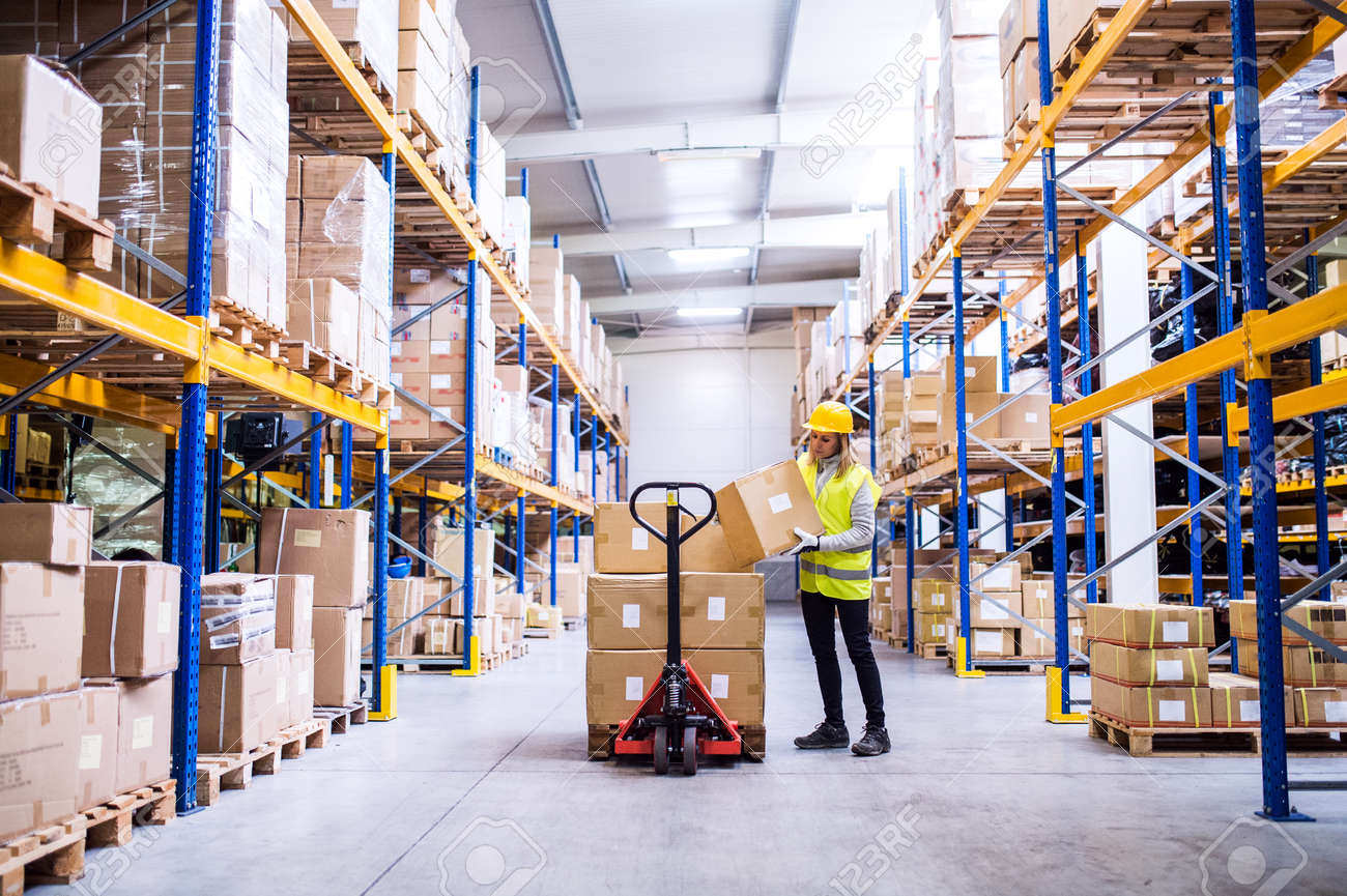 Female warehouse worker loading or unloading boxes. - 92049923 Female warehouse worker loading or unloading boxes. - 92049923