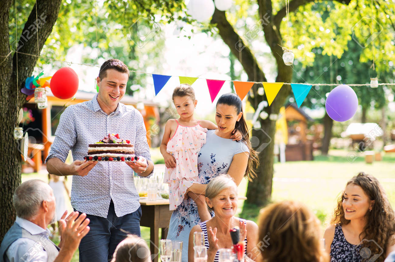 Family celebration or a garden party outside in the backyard. - 102777745 Family celebration or a garden party outside in the backyard. - 102777745