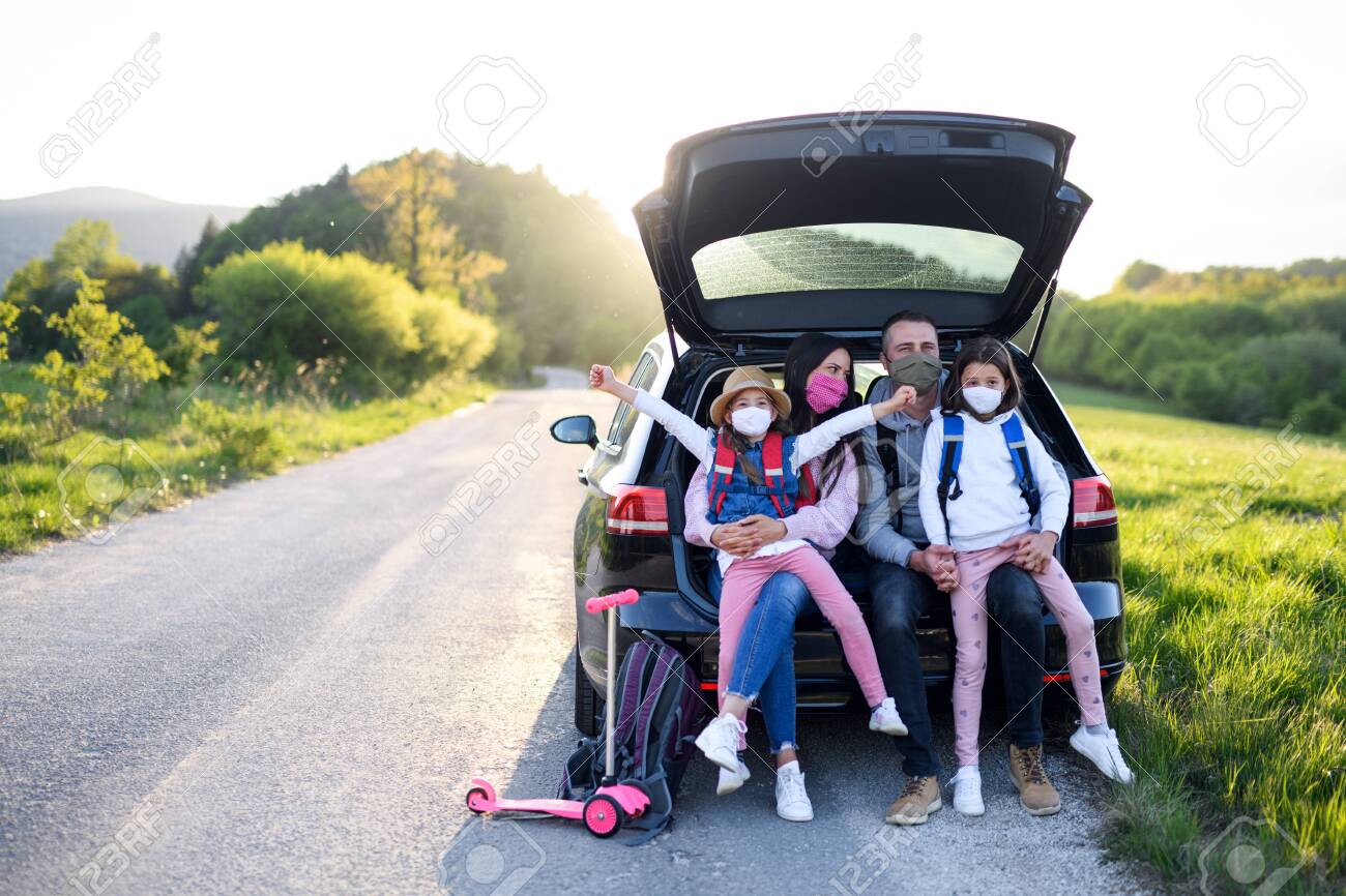 Family with two small daughters on trip outdoors in nature, wearing face masks. - 149898938 Family with two small daughters on trip outdoors in nature, wearing face masks. - 149898938
