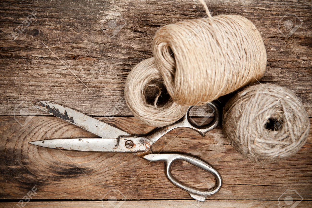Old rusty scissors and skein jute on wooden table. Top view. - 33012144 Old rusty scissors and skein jute on wooden table. Top view. - 33012144