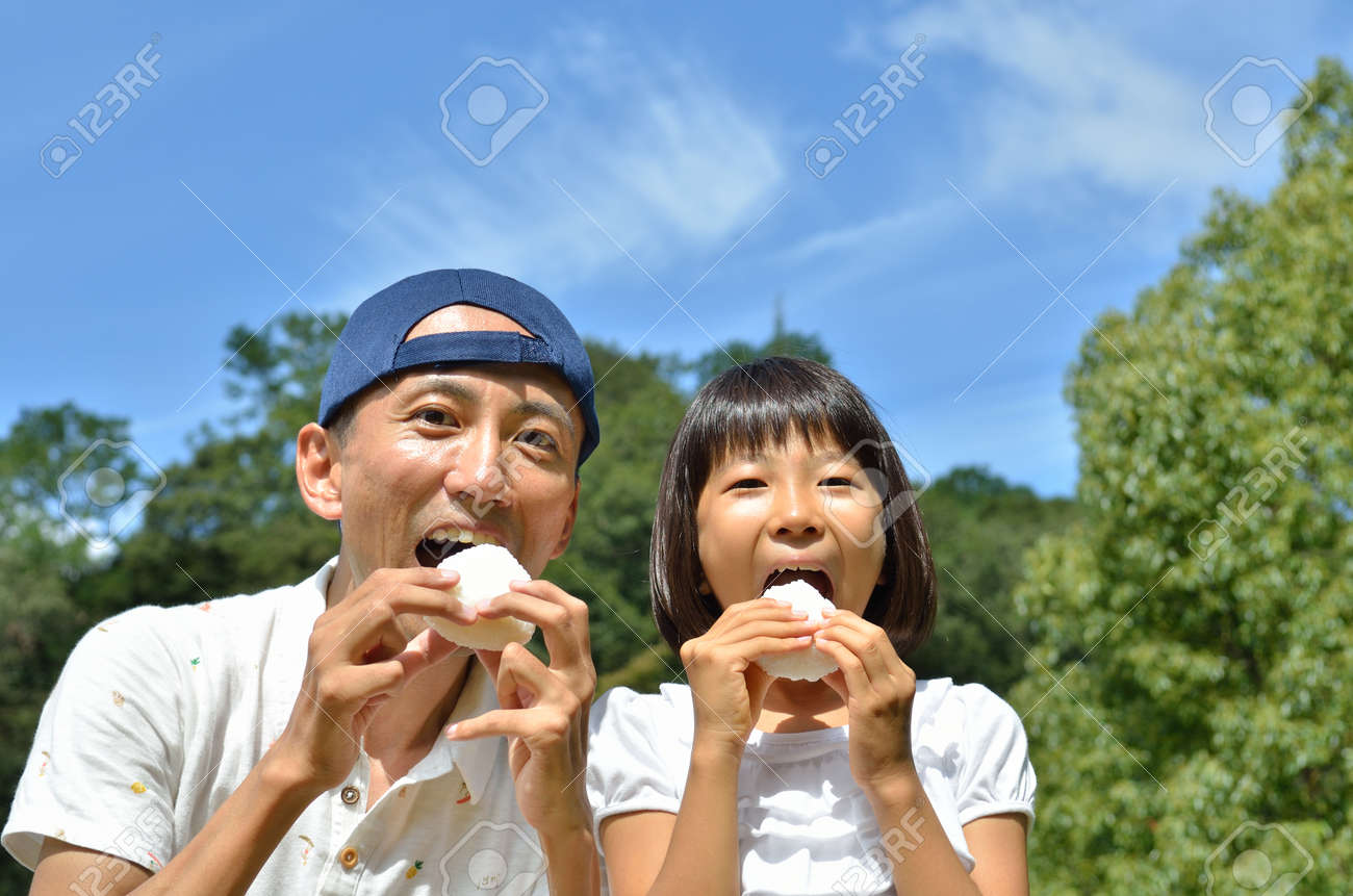 日本の親と子がおにぎりを食べる の写真素材 画像素材 Image