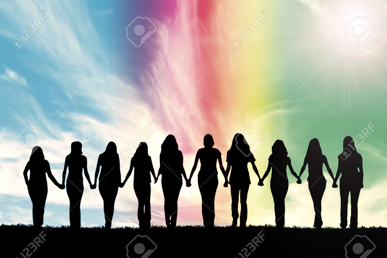 Silhouette of ten young women, walking hand in hand under a rainbow sky. - 60214177 Silhouette of ten young women, walking hand in hand under a rainbow sky. - 60214177