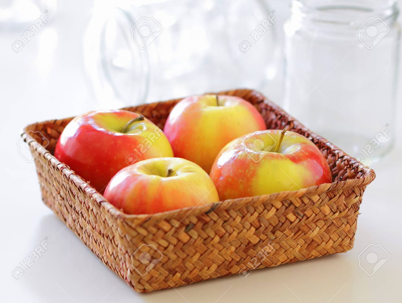 Four Apples In A Basket On A Kitchen Table Ready To Make Apple