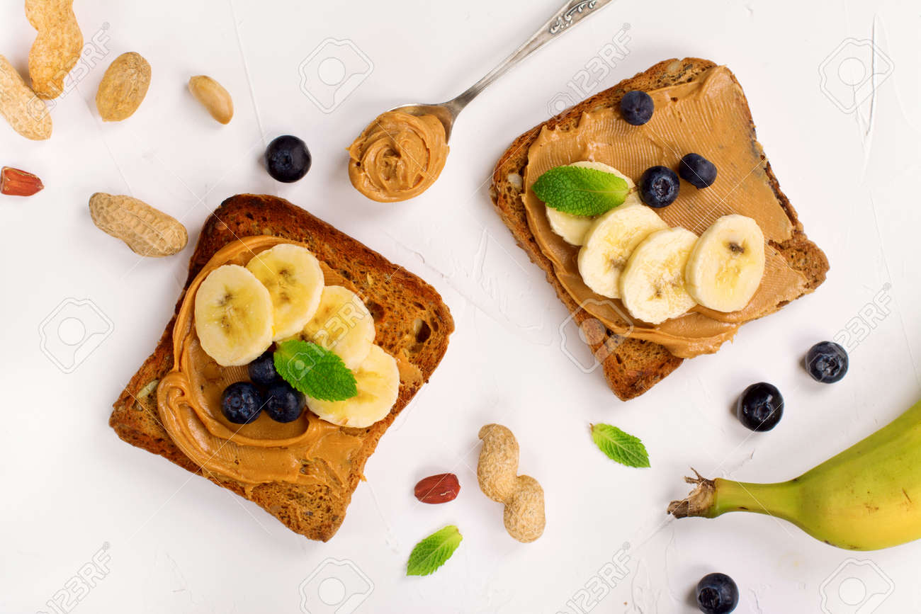 Peanut butter sandwiches with bananas and blueberry. Top view. Space for text - 60524079 Peanut butter sandwiches with bananas and blueberry. Top view. Space for text - 60524079
