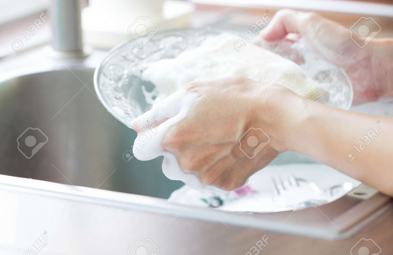Close Up Woman Hand Holding Yellow Sponge And Washing Saucer With Washed Dishes - 61909942 Close Up Woman Hand Holding Yellow Sponge And Washing Saucer With Washed Dishes - 61909942