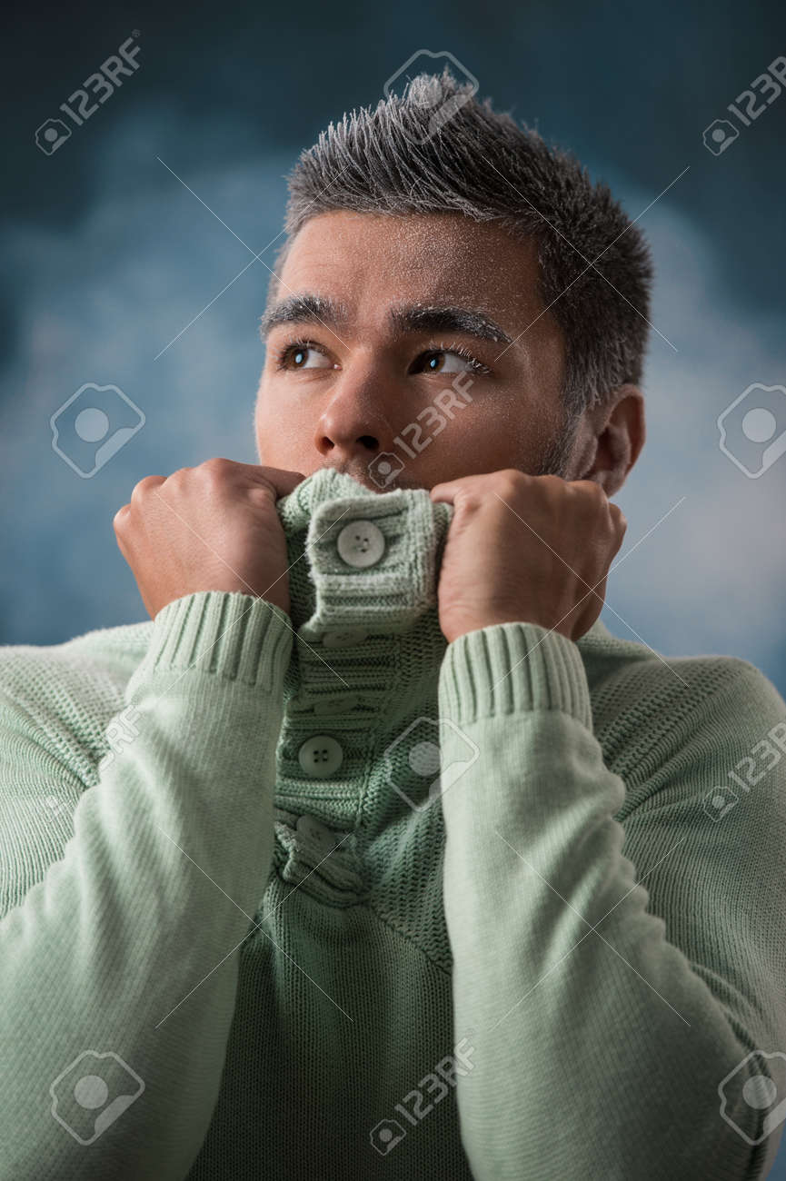 男性の冬のファッション 緑のジャージを着ている黒髪のハンサムな男性 雪で覆われています 寒い カジュアルな表情 煙のような暗い背景の撮影スタジオ の写真素材 画像素材 Image