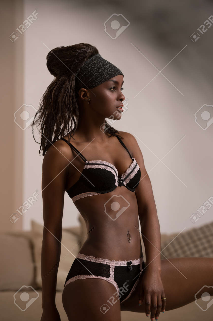 Belle femme africaine séduisante dans la lingerie sexy. Portrait de la belle  élégant modèle de jeune femme sexy avec la peau parfaitement propre en  lingerie noire posant à la maison à travers