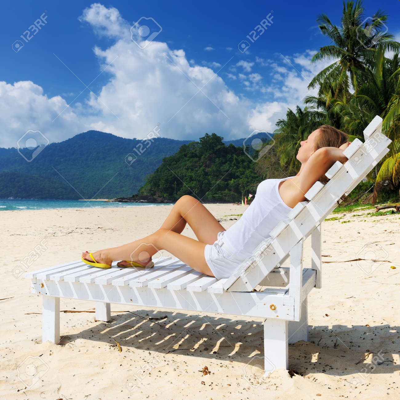 Fille Sur Une Plage Tropicale Assis à Une Chaise Longue