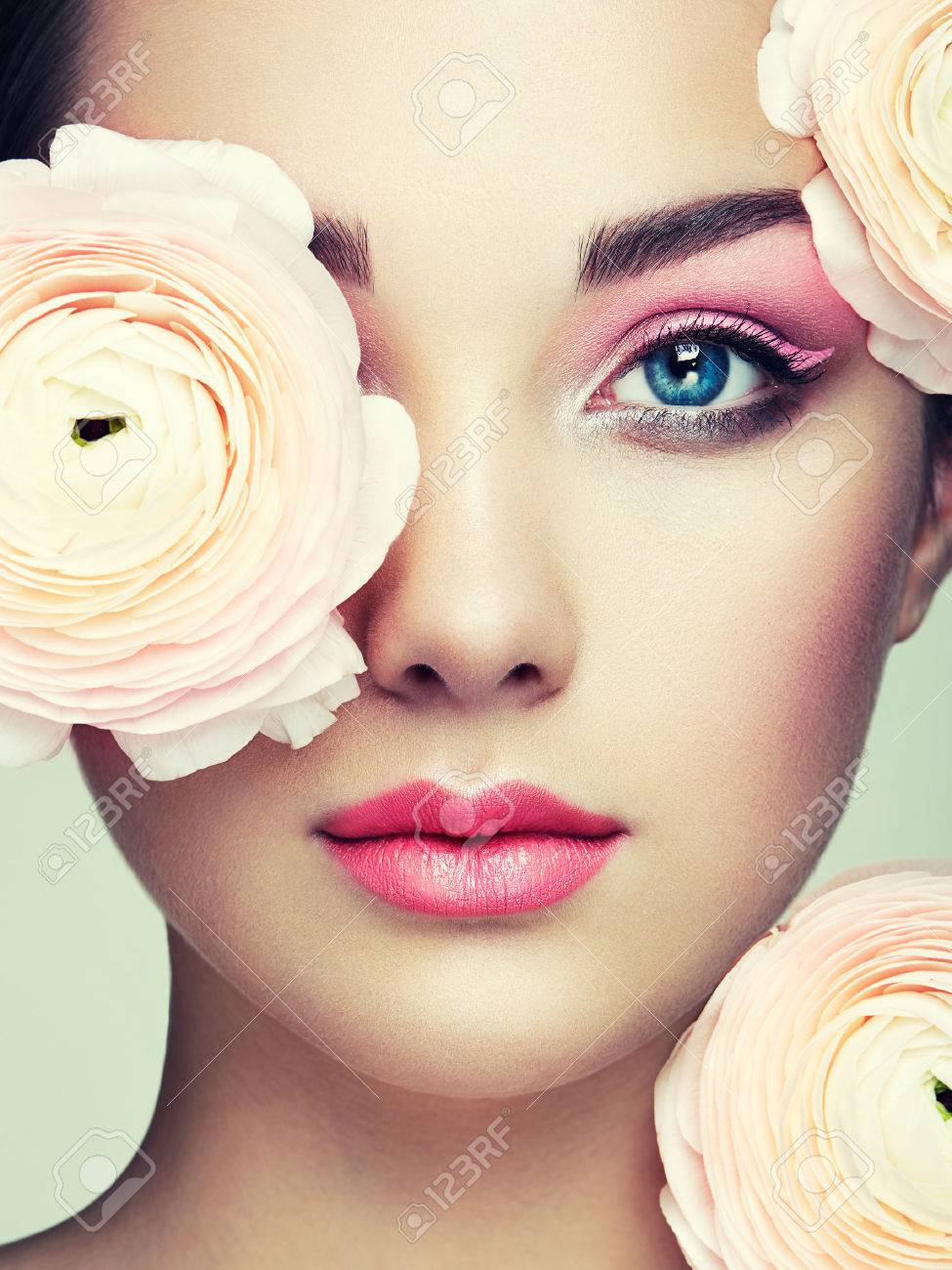 Portrait of beautiful young woman with flowers. Brunette woman with luxury makeup. Perfect skin. Eyelashes. Cosmetic eyeshadow - 65173856 Portrait of beautiful young woman with flowers. Brunette woman with luxury makeup. Perfect skin. Eyelashes. Cosmetic eyeshadow - 65173856