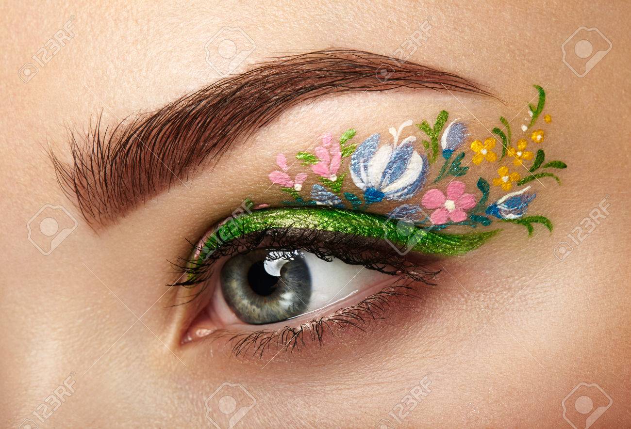 Eye makeup girl with a flowers. Spring makeup. Beauty fashion. Eyelashes. Cosmetic Eyeshadow. Make-up detail. Creative woman holiday make-up - 74276928 Eye makeup girl with a flowers. Spring makeup. Beauty fashion. Eyelashes. Cosmetic Eyeshadow. Make-up detail. Creative woman holiday make-up - 74276928