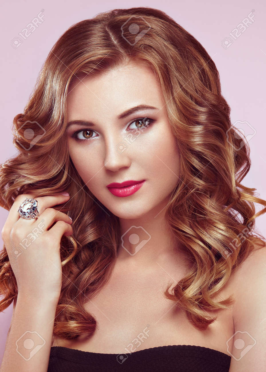 光沢のある長いとボリュームのウェーブのかかった髪と金髪の女性 巻き