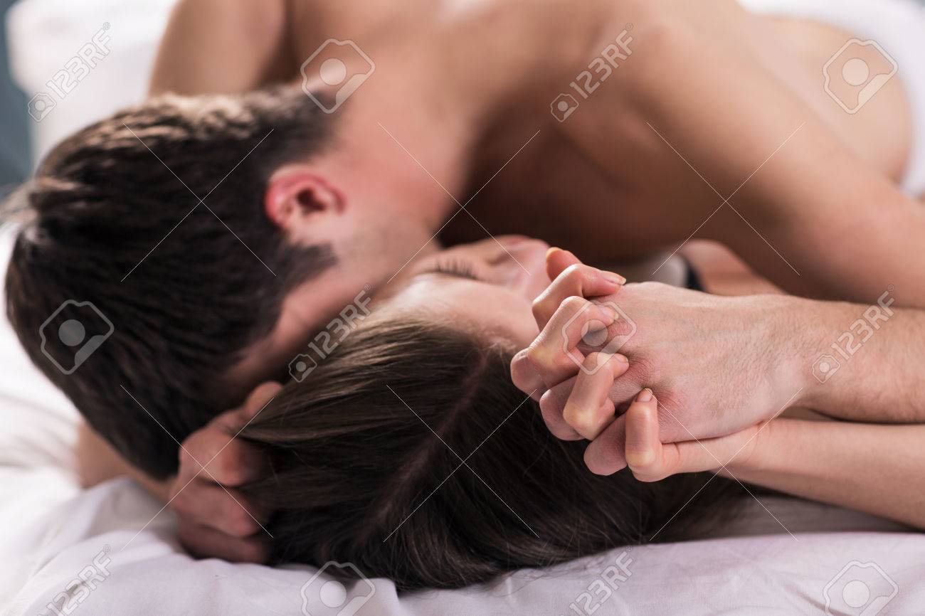 Yatakta Öpüşme Genç Aşıklar El Odaklanmış Royalty Free Stok Fotoğraf,  Resimler, Görseller ve Stok Fotoğrafçılık. Image 29937344