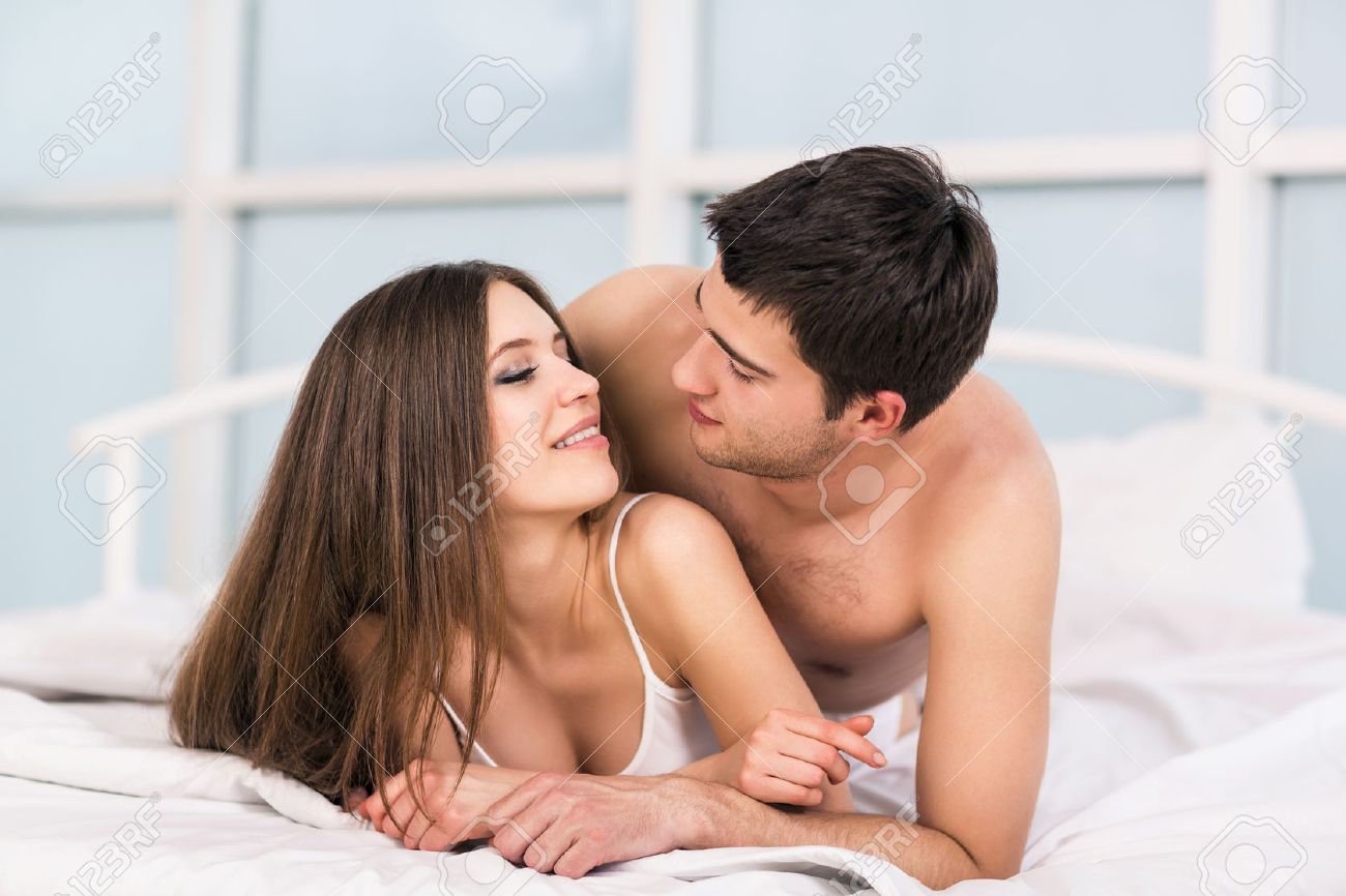 Young Love Couple In Bed Romantic Scene In Bedroom Stock Photo