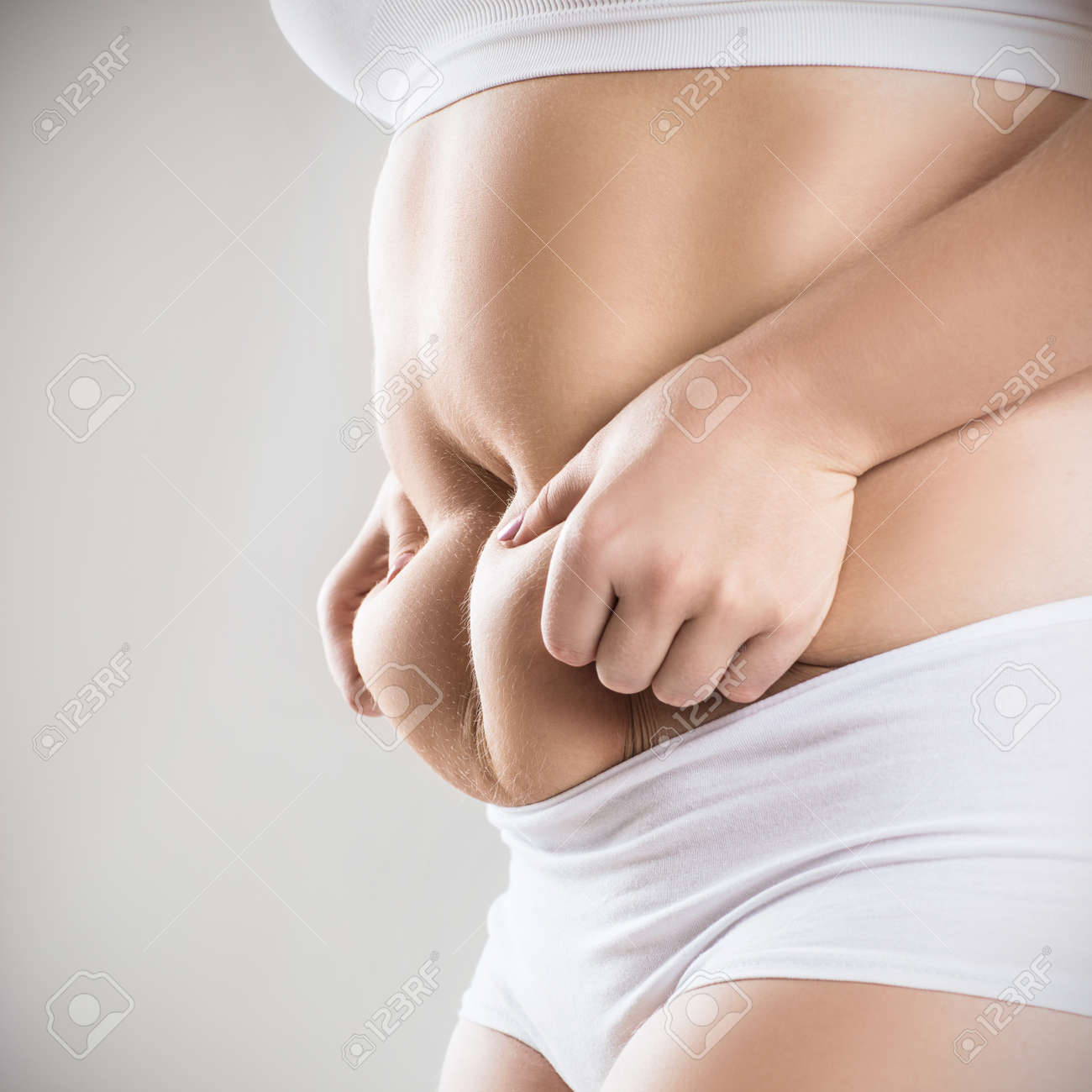 Woman In White Underwear Holds Belly Fat. Stock Photo, Picture and